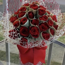 Red roses wrapped in 20 bills in a clear vase by lav.ishbouquets