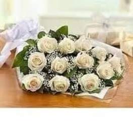 12 White Roses Long Stem in a wrap bouquet with greenery as shown.