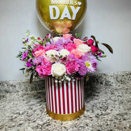 Pink and white flower arrangement with a gold Mother's Day balloon