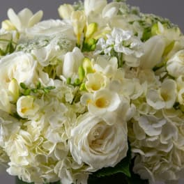 White floral bouquet with roses, hydrangeas, and freesia