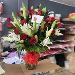 Red roses with lilies arrangement in vase
