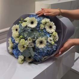 very beautiful bouquet with blue hydrangeas and gerberas