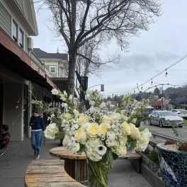 Tall white floral arrangement in a clear glass vase