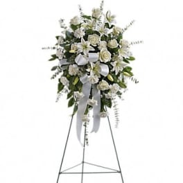 White floral standing spray on an easel with ribbon