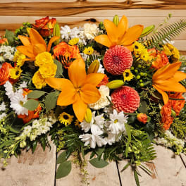 Large orange, yellow, and white floral arrangement on a table