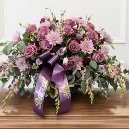 Large purple floral spray with roses and daisies, tied with a ribbon