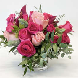 Pink and blush roses arranged in a clear glass vase