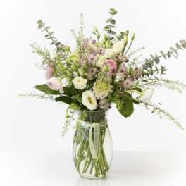 Mixed pastel bouquet in a clear glass vase with a ribbon