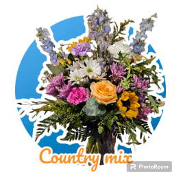 Mixed bouquet with a peach rose, sunflower, daisies, and purple blooms
