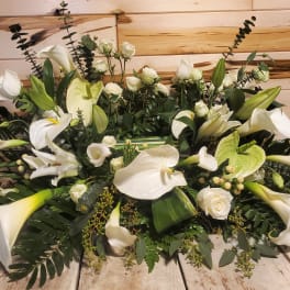 Large white floral arrangement with calla lilies and roses