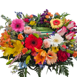 Colorful mixed flower arrangement with gerbera daisies, roses, lilies, and orchids