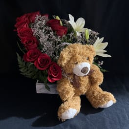 Red rose arrangement with white lilies and a teddy bear
