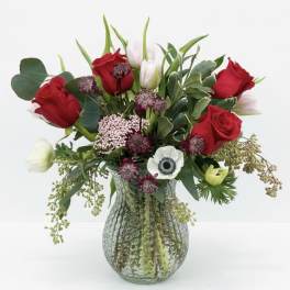 Red roses and white tulips in a glass vase