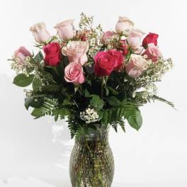 Pink and red roses arranged in a glass vase
