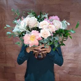 Large bouquet of pale pink and white roses in a glass vase
