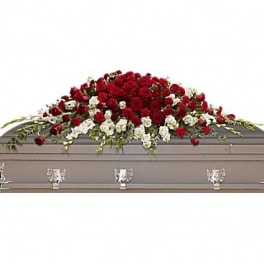 Red and white floral spray on a gray casket