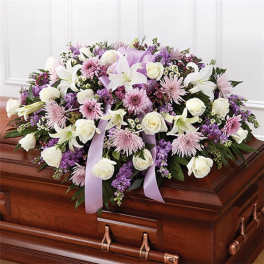 Lavender and white floral spray on a casket