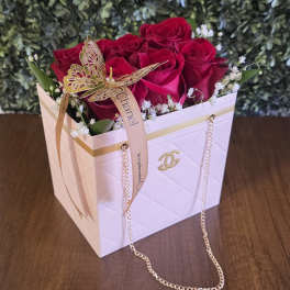 Red roses in a white gift box with a ribbon and butterfly decoration