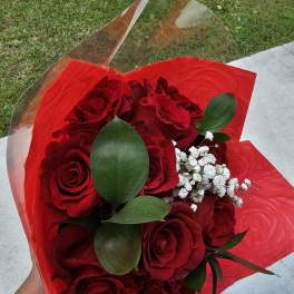Bouquet of red roses with white baby's breath wrapped in red paper