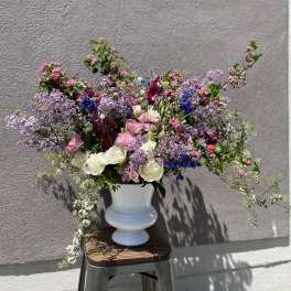 Large mixed bouquet in a white vase with pink, purple, and white flowers