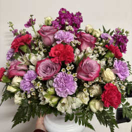 Pink and lavender flower arrangement in a white vase