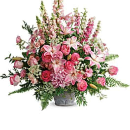 Pink roses and lilies arranged in a gray vase