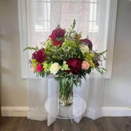 Large mixed bouquet of roses and greenery in a glass vase