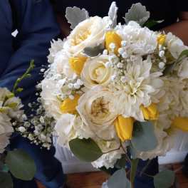 Bouquet of white and yellow flowers with soft gray-green foliage