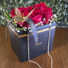 Red roses in a Dior gift box with a butterfly ribbon and chain handle