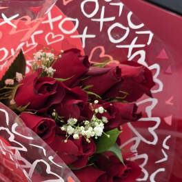 Bouquet of deep red roses with white baby's breath in pink wrap