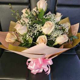 Bouquet of pale peach roses with baby's breath and pink ribbon