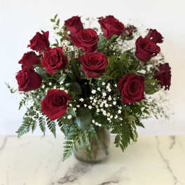 Bouquet of red roses in a glass vase with baby's breath