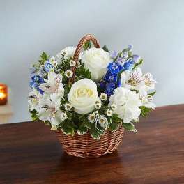 Basket of white and blue flowers on a table