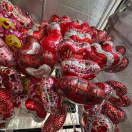 Cluster of heart-shaped Valentine balloons in red, pink, and silver