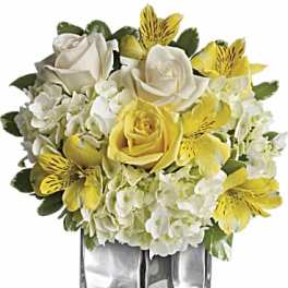 Yellow and white roses with alstroemeria in a clear square vase
