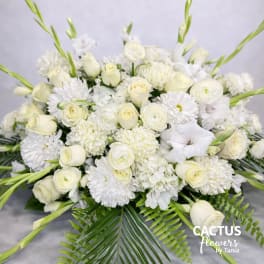 White floral arrangement with roses, chrysanthemums, and gladiolus