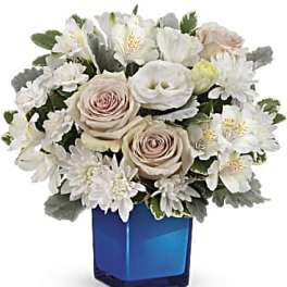 White and blush bouquet in a blue glass vase