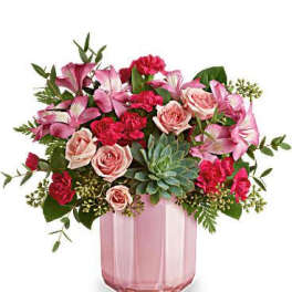 Pink and red flower arrangement in a pink glass vase
