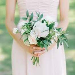 Bride holding a white and blush bouquet with greenery