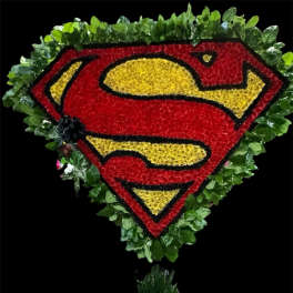 Superman logo floral tribute with red, yellow, and black flowers