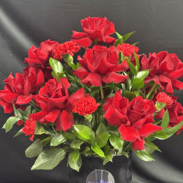 Red roses and carnations in a black hat box
