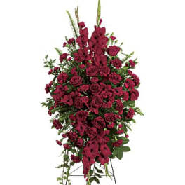 Tall standing spray of dark red roses and carnations on a metal easel