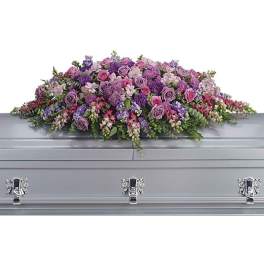 Lavender and pink floral casket spray on a silver casket