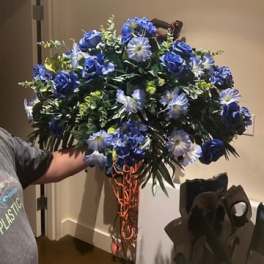 Large blue floral arrangement with roses and daisy-like blooms