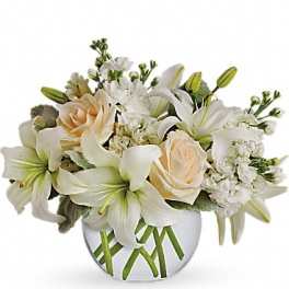 White lilies and cream roses arranged in a round vase