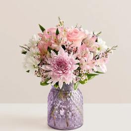 Pink and white bouquet in a purple textured vase