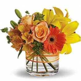 Orange roses and yellow lilies in a clear glass vase