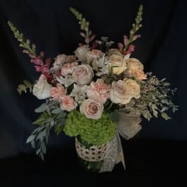 Bouquet of pale roses and pink carnations in a decorative vase