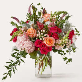 Mixed bouquet of pink and peach roses in a clear glass vase