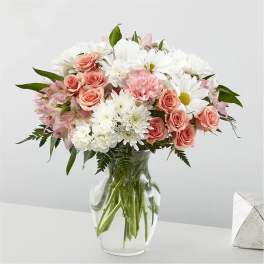 Pink roses and white daisies in a clear glass vase